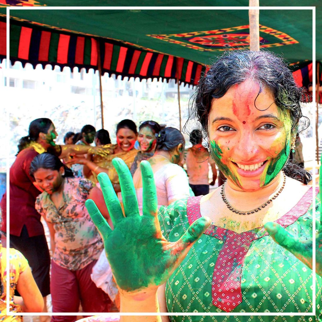Celebrations of Holi Festival with colours and happiness shown by the Indian Woman with her hands and face with colours of Joy
