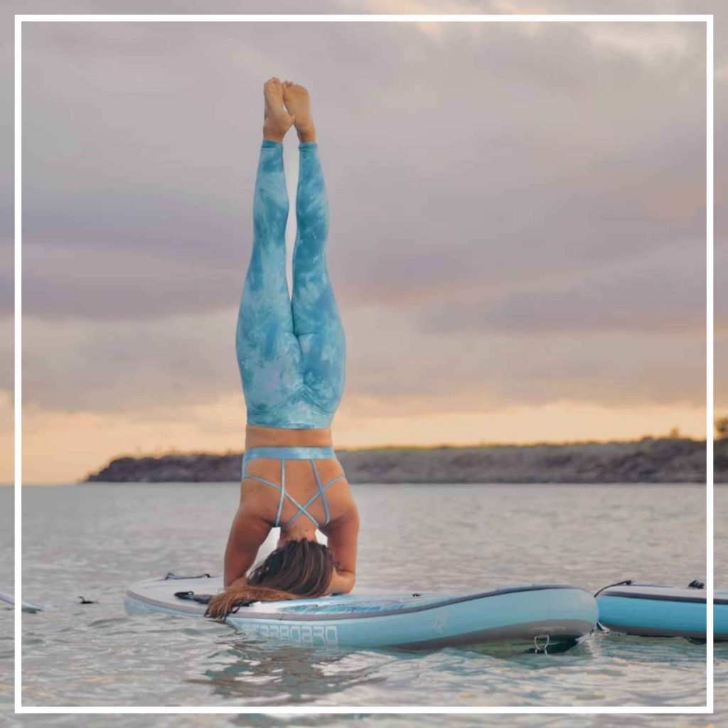 Woman doing yoga on a stand up paddle board
